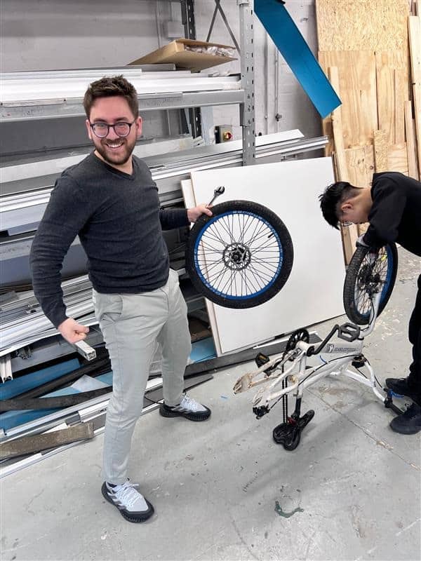 Team members sanding body panels during the soapbox build weekend